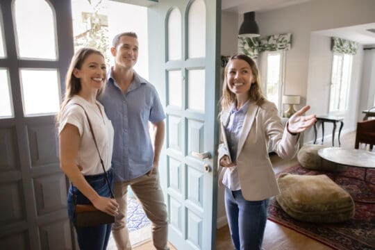 First-time home buyers touring a house with a real estate agent.
